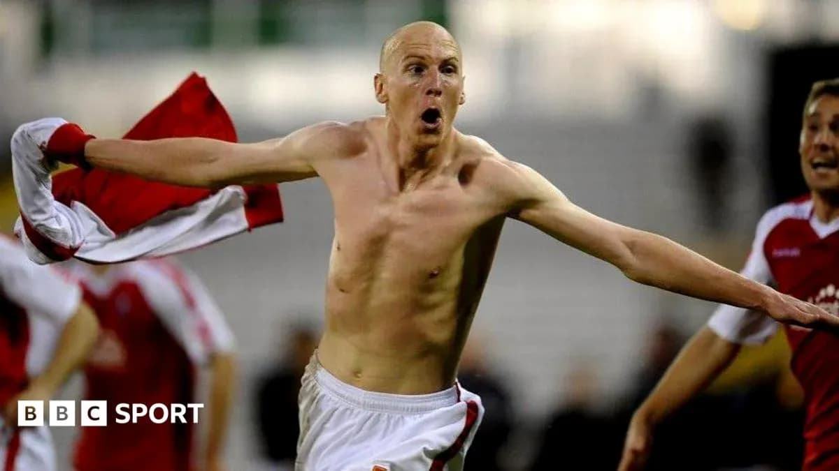 Player celebrating goal with shirt raised in stadium Player celebrating goal with shirt raised in stadium