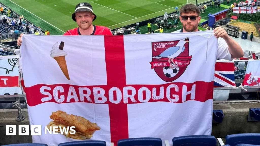 Ikkita muxlis Scarborough bayrog'ini ko'tarib turibdi Ikkita muxlis Scarborough bayrog'ini ko'tarib turibdi