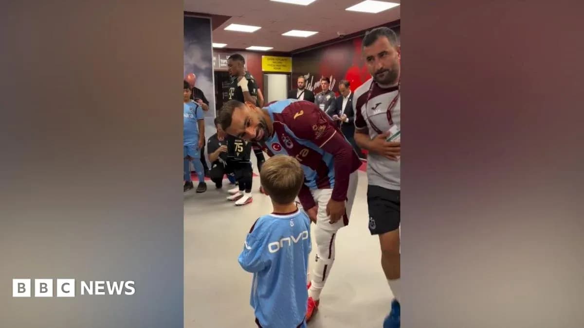 Futbolchi va kichkina bola kiyinish xonasida Futbolchi va kichkina bola kiyinish xonasida