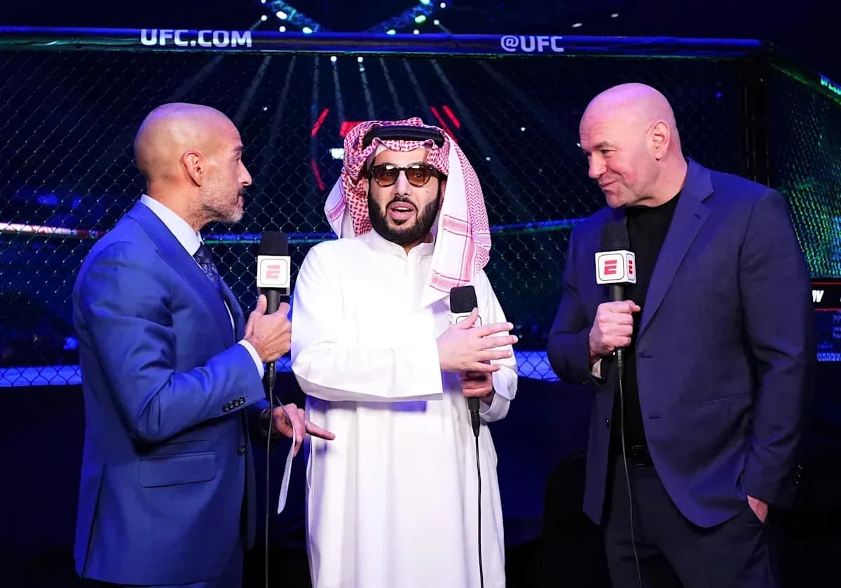 Three men speaking near UFC octagon during event Three men speaking near UFC octagon during event