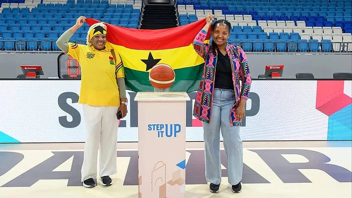 Two women holding Ghana flag and basketball on court Two women holding Ghana flag and basketball on court