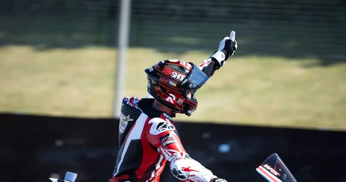Motocross racer celebrating victory with raised hand Motocross racer celebrating victory with raised hand