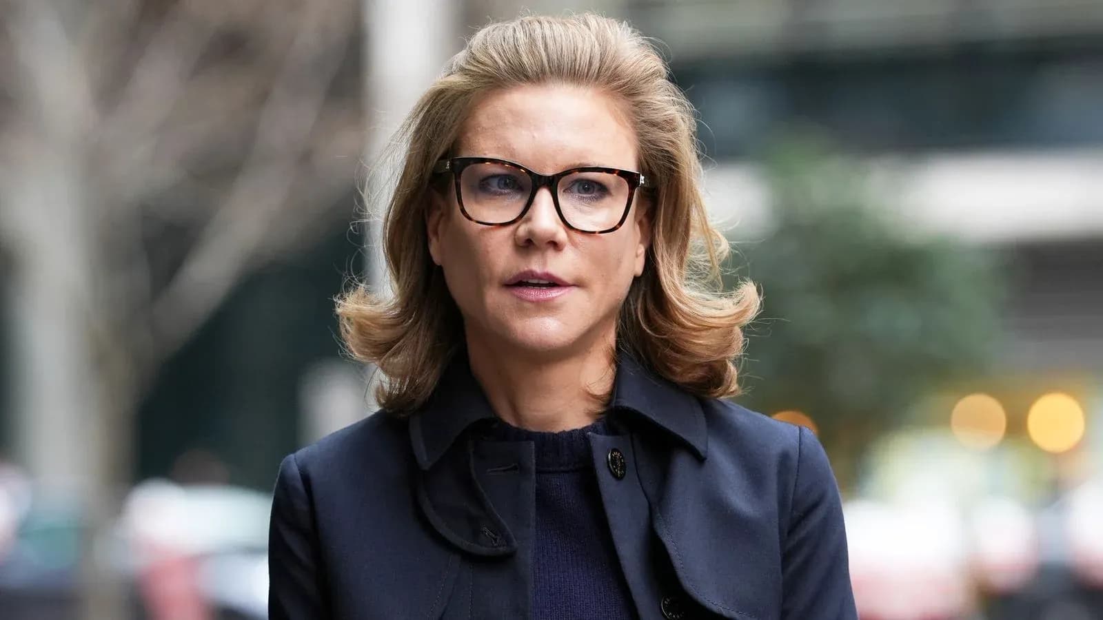 Woman in glasses walking outdoors in urban setting Woman in glasses walking outdoors in urban setting