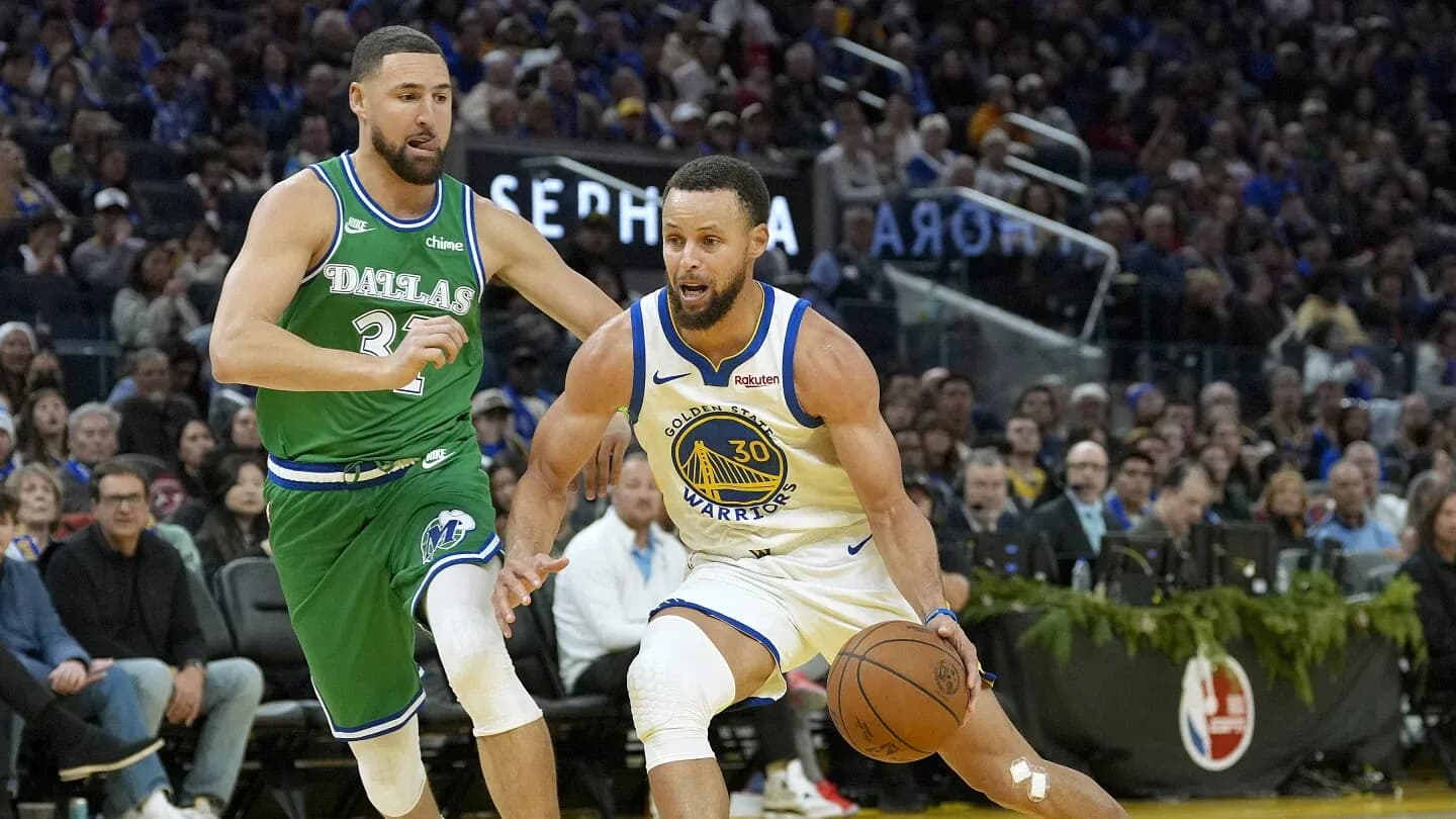 Stephen Curry dribbling past defender during game Stephen Curry dribbling past defender during game