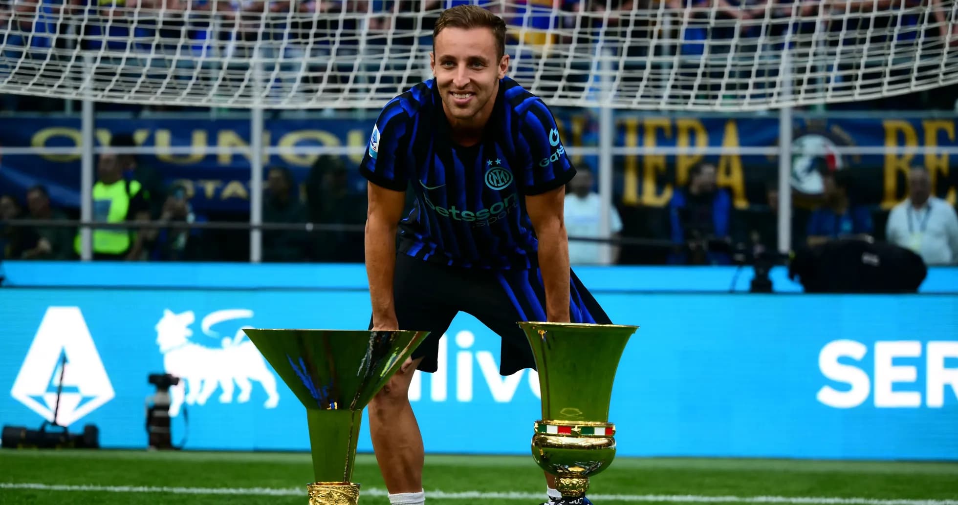 Futbolchi troflar bilan maydonda turibdi Futbolchi troflar bilan maydonda turibdi