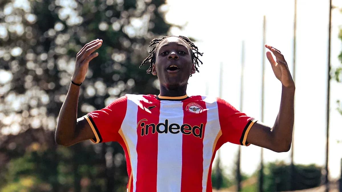 Futbolchi Brentford formasida qo'llarini ko'tarib turibdi Futbolchi Brentford formasida qo'llarini ko'tarib turibdi