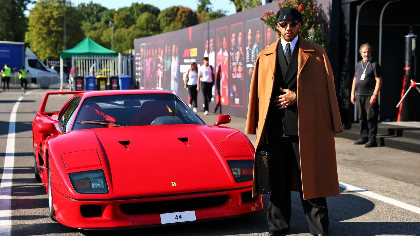 Shirted man in coat beside a red Ferrari Shirted man in coat beside a red Ferrari