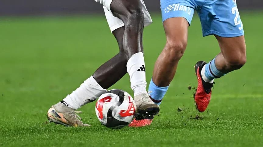 Two players contesting for the ball on pitch Two players contesting for the ball on pitch