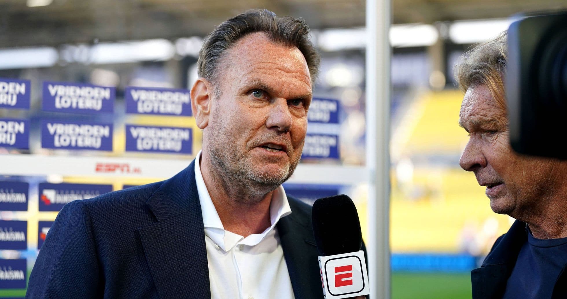 Interviewer speaking with a football manager on site Interviewer speaking with a football manager on site