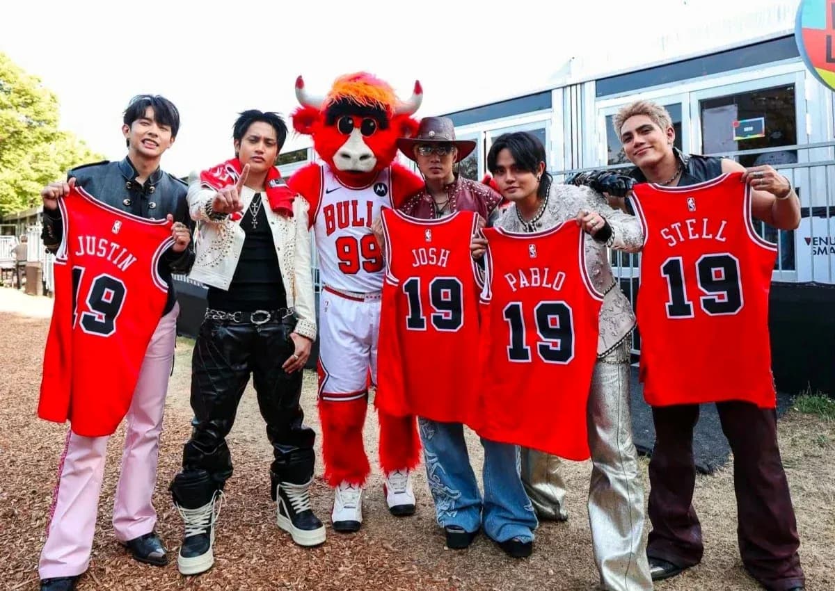 Group holding jerseys with a mascot at event Group holding jerseys with a mascot at event
