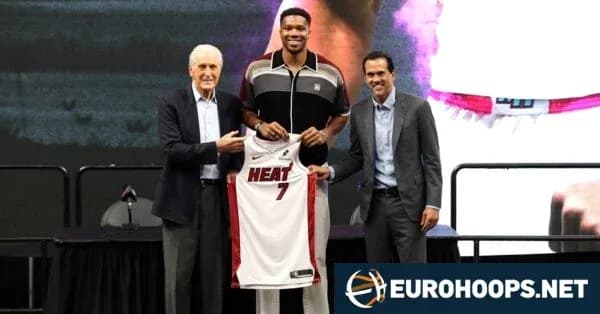 Basketball player holding Miami Heat jersey with coaches Basketball player holding Miami Heat jersey with coaches