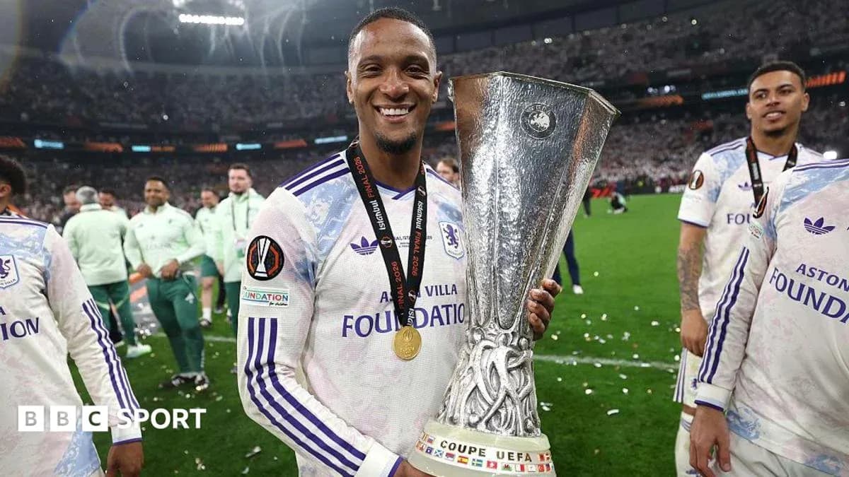 O'yinchi UEFA Kubogini tutib turgan holatda O'yinchi UEFA Kubogini tutib turgan holatda