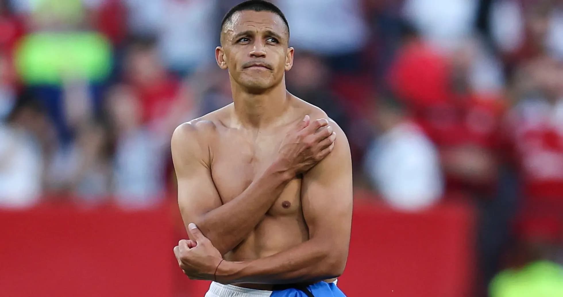 Football player standing shirtless on the field Football player standing shirtless on the field