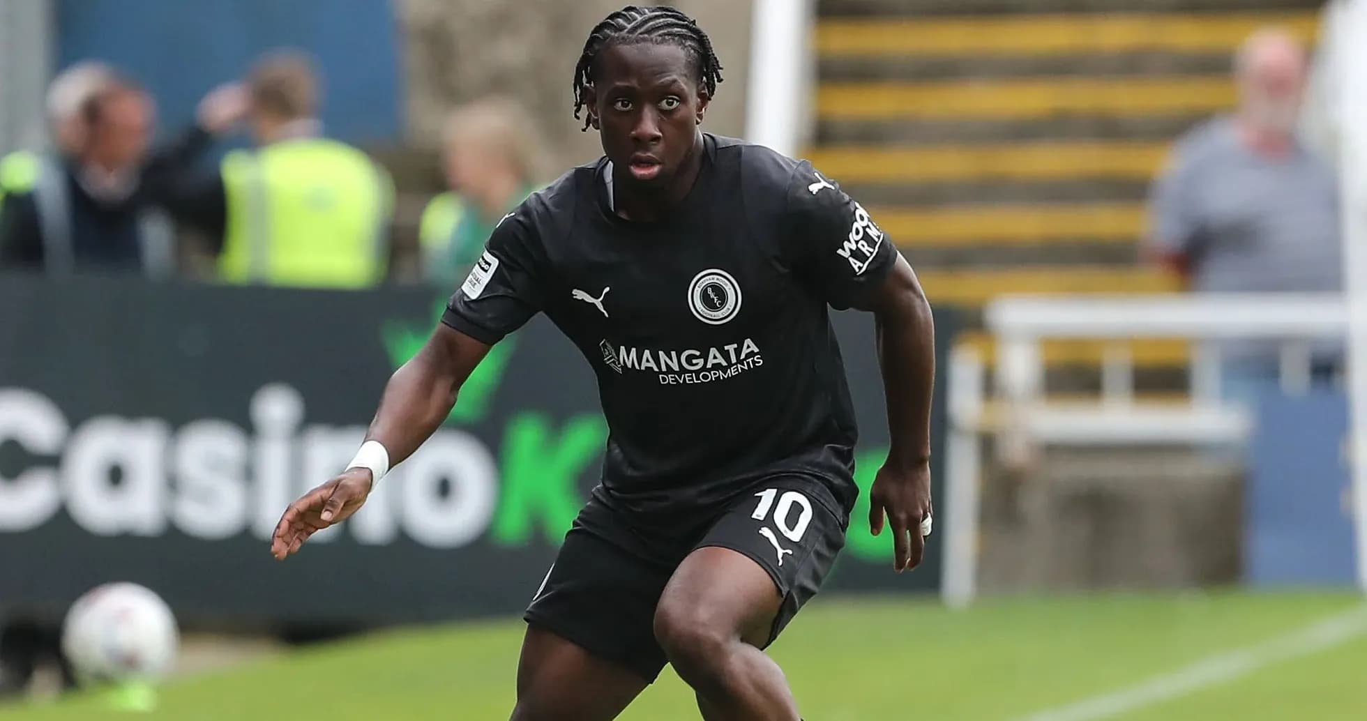Futbolchi qora formada maydon bo'ylab harakatda Futbolchi qora formada maydon bo'ylab harakatda