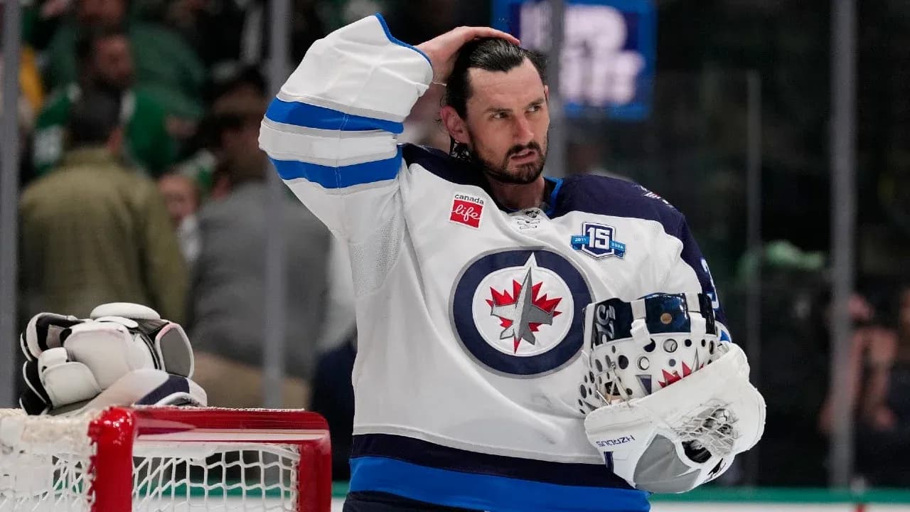 Hockey player in Winnipeg Jets uniform holding helmet Hockey player in Winnipeg Jets uniform holding helmet