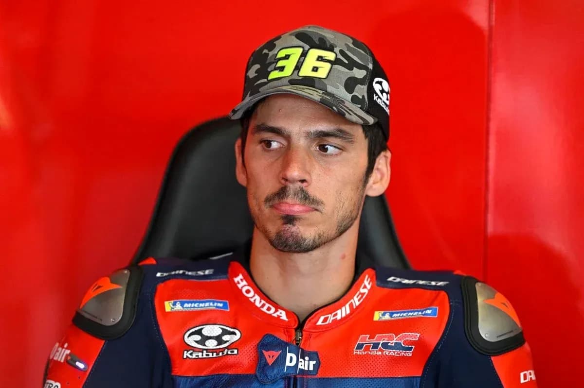 MotoGP rider in team gear sitting in garage MotoGP rider in team gear sitting in garage