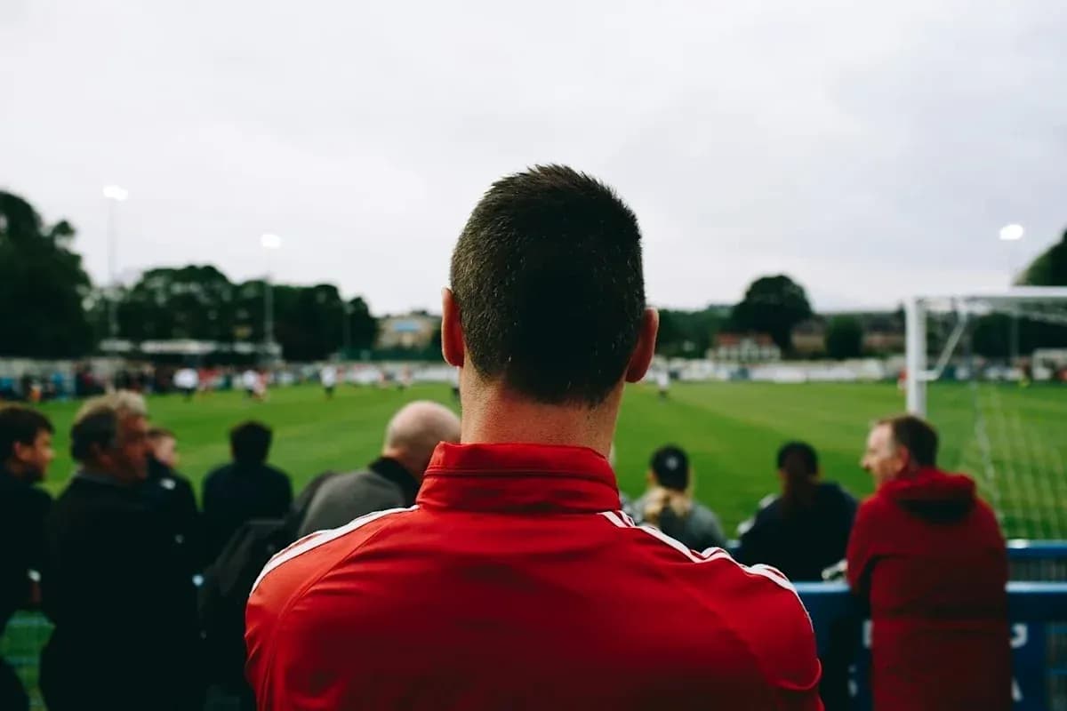 Fan watching football match from the sidelines Fan watching football match from the sidelines