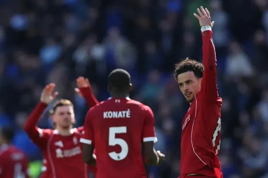 Ikkita futbolchi va Konate maydonda ko'tarilgan qo'l bilan Ikkita futbolchi va Konate maydonda ko'tarilgan qo'l bilan