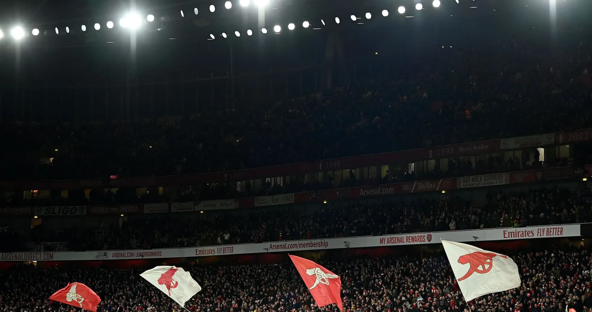 Arsenal fans waving flags at Emirates Stadium Arsenal fans waving flags at Emirates Stadium