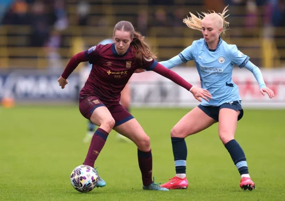 Two female players competing for the ball in match Two female players competing for the ball in match
