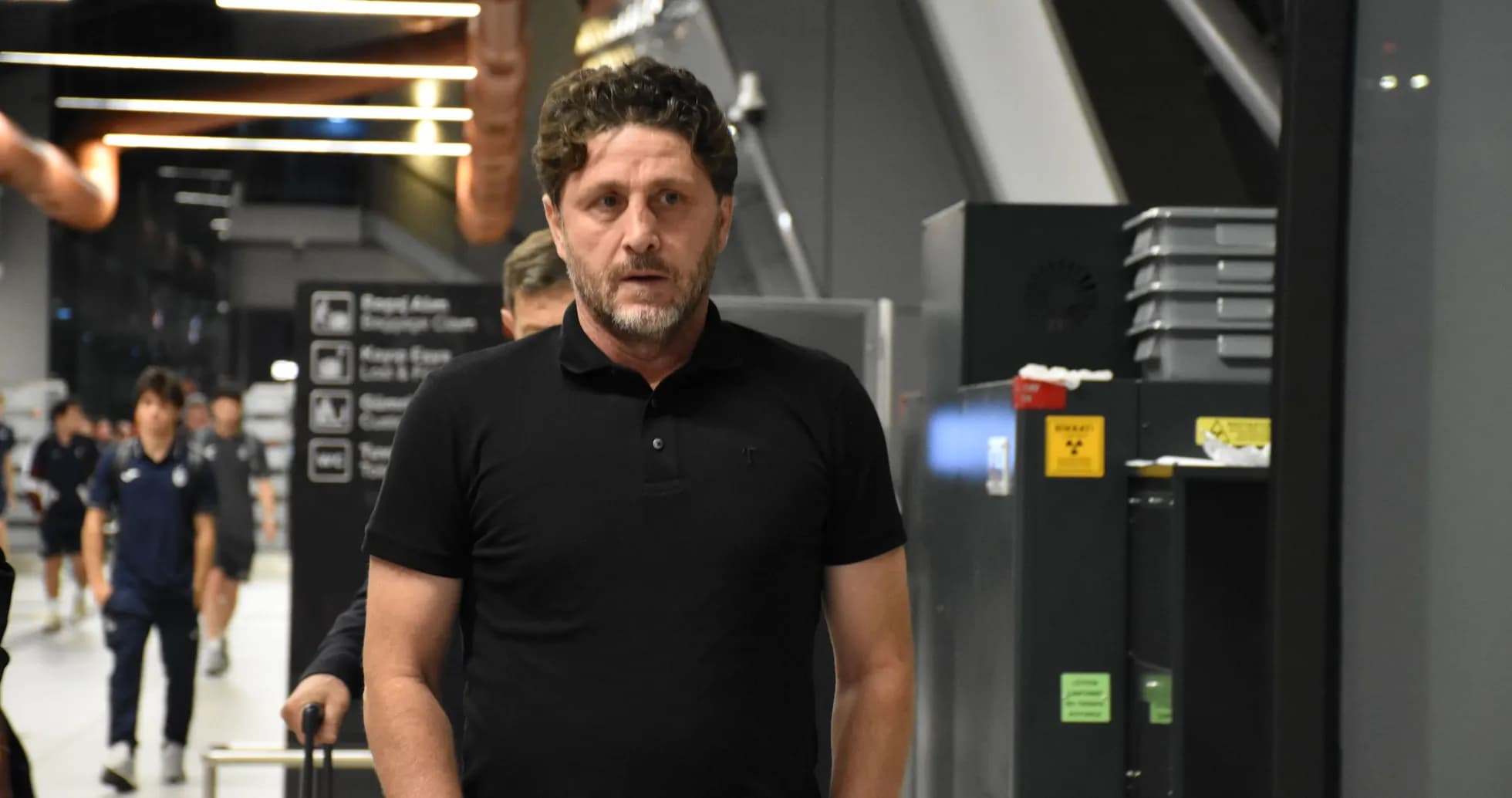 Football coach walking in airport terminal Football coach walking in airport terminal