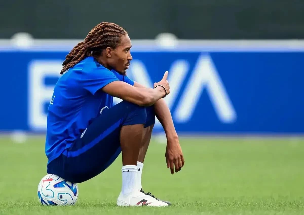 Futbolchi o'yin to'piga suyangan holda o'tirgan Futbolchi o'yin to'piga suyangan holda o'tirgan