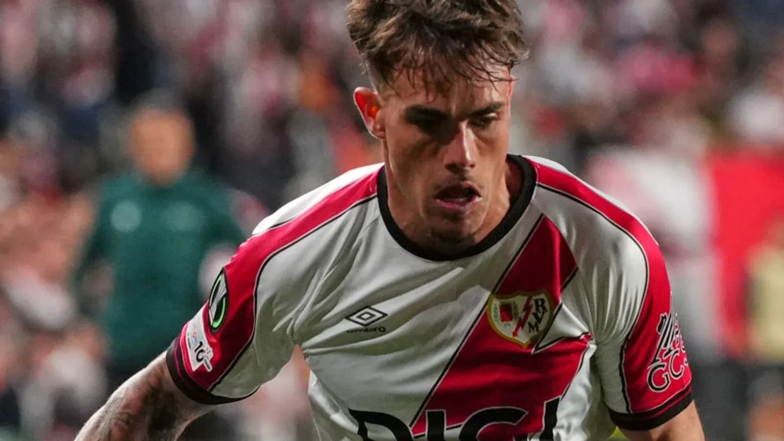 Futbolchi Rayo Vallecano formasida to'pni quchoq qilmoqda Futbolchi Rayo Vallecano formasida to'pni quchoq qilmoqda
