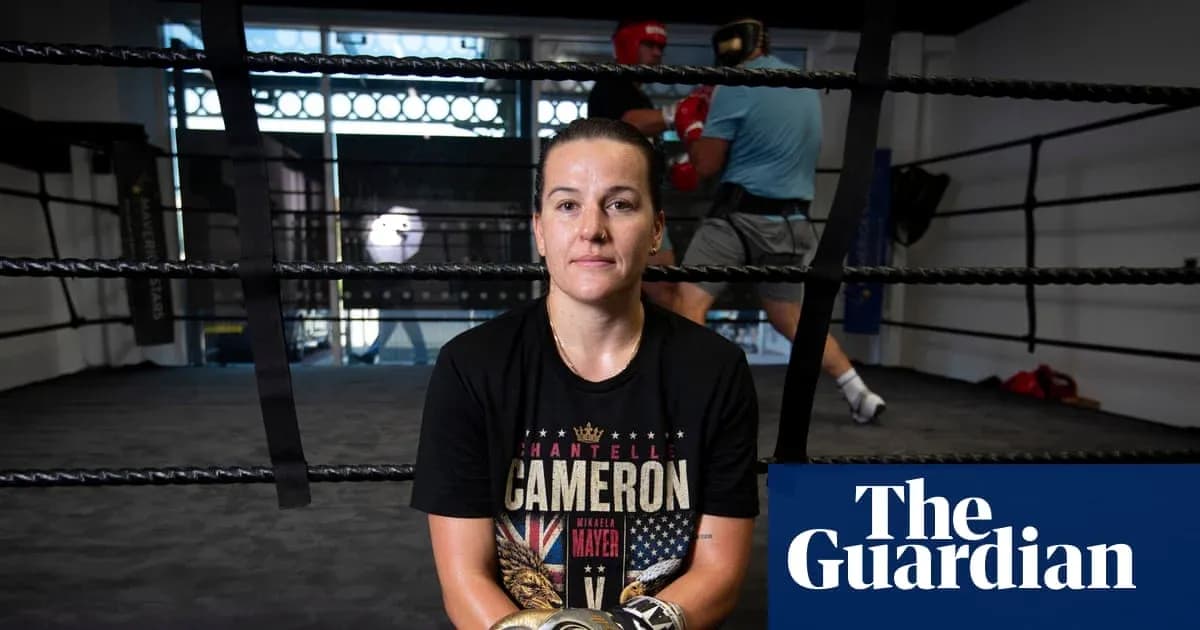 Boxer sitting in ring with training partners in background Boxer sitting in ring with training partners in background
