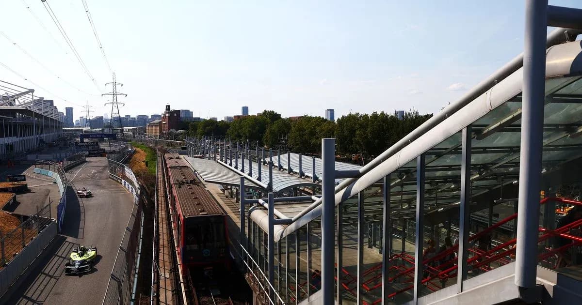Formula E car racing near train station and city skyline Formula E car racing near train station and city skyline