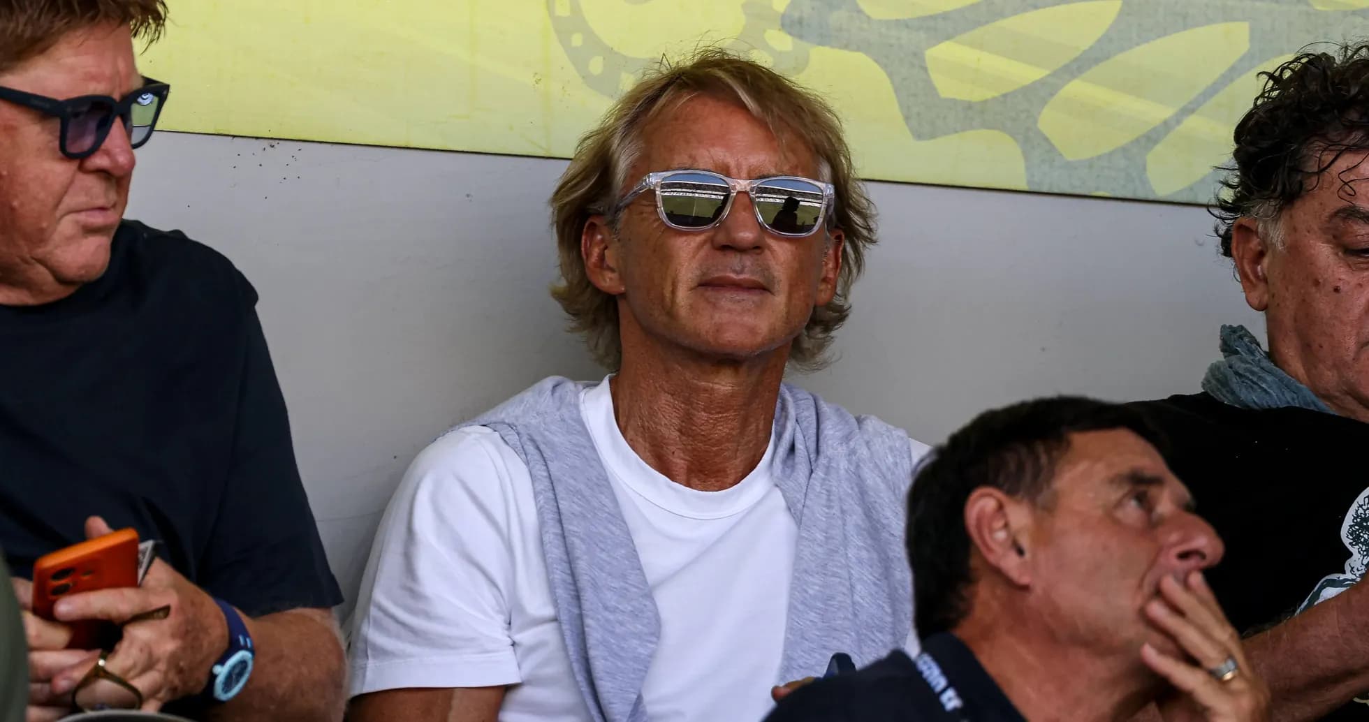 Man with sunglasses sitting among spectators Man with sunglasses sitting among spectators