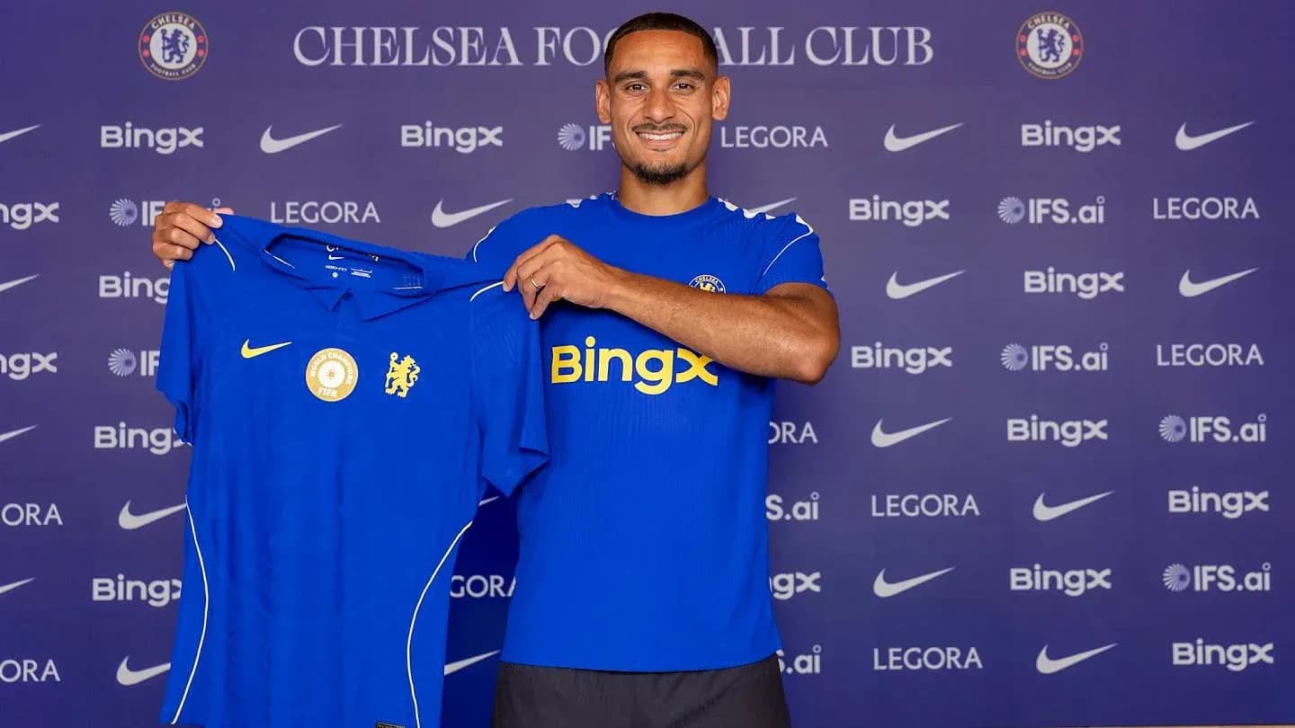 Futbolchi Chelsea formasini tutib turib tabriklanmoqda Futbolchi Chelsea formasini tutib turib tabriklanmoqda