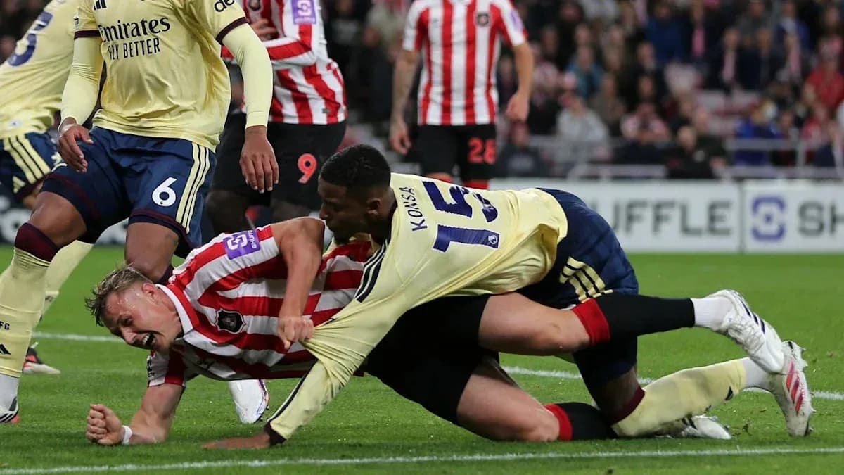 Two players battling for the ball on the ground Two players battling for the ball on the ground