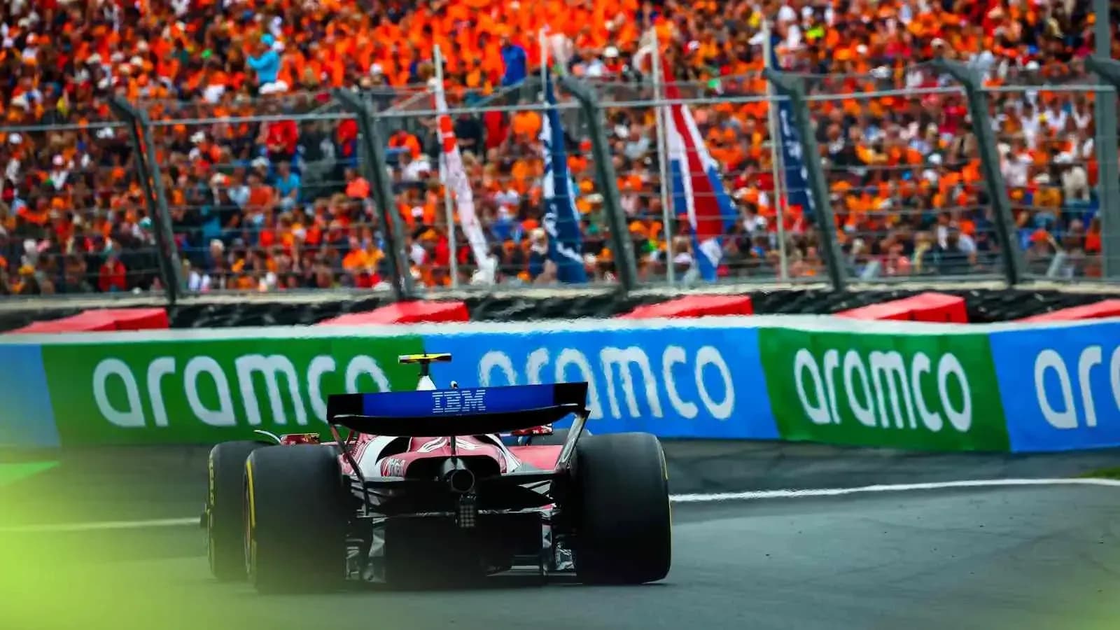 Formula 1 car racing past a cheering crowd Formula 1 car racing past a cheering crowd