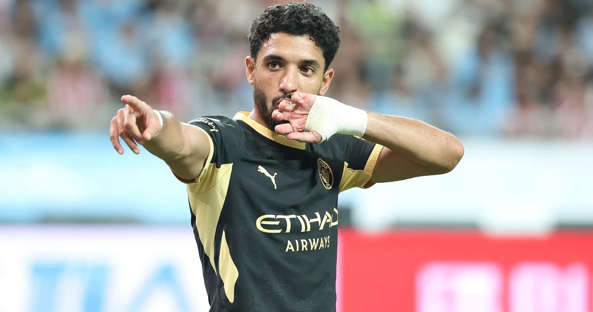 Futbolchi maydonda qo'lini ko'tarib ishora qilmoqda Futbolchi maydonda qo'lini ko'tarib ishora qilmoqda