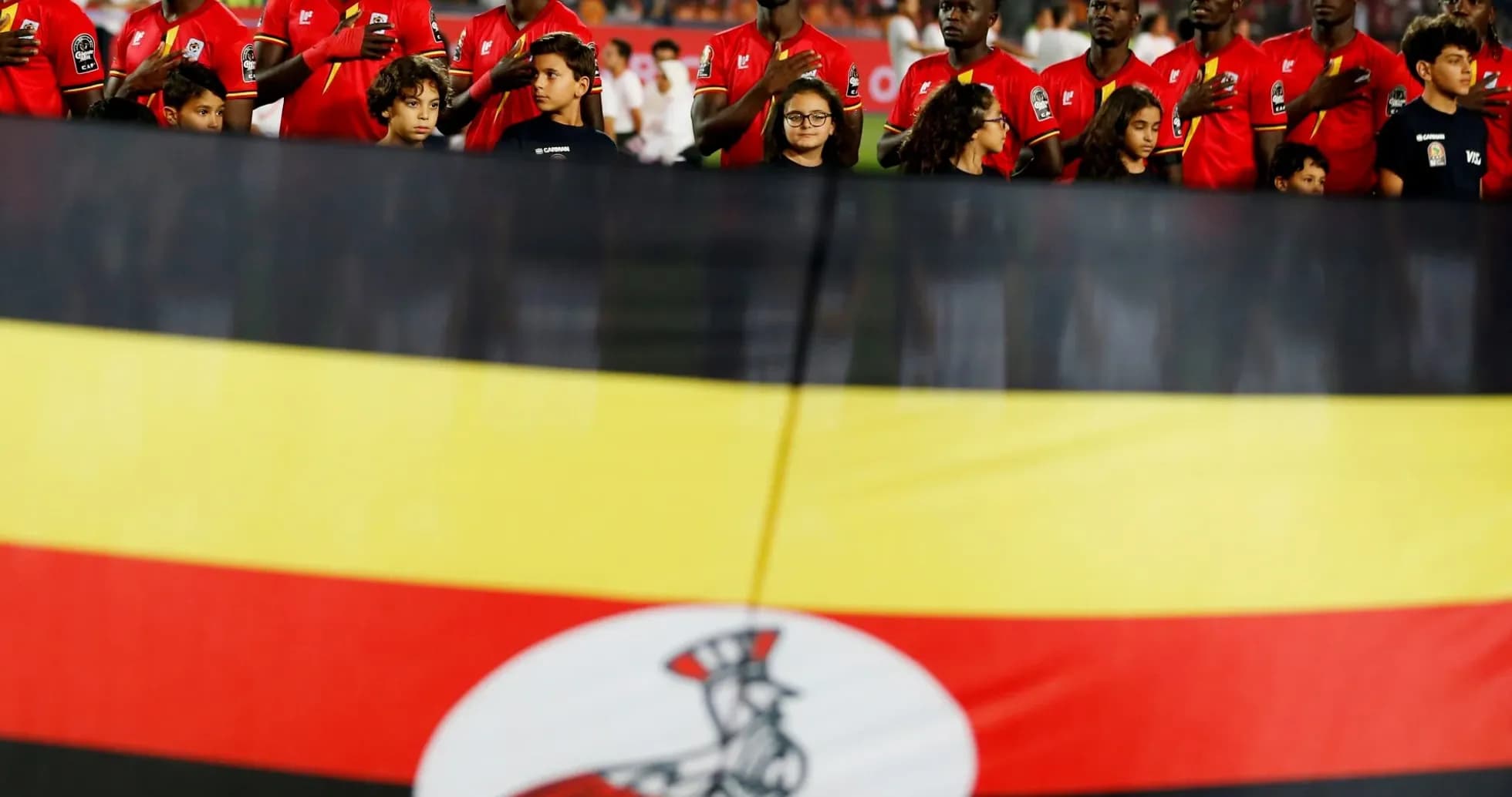 Ugandan team standing with flag before match Ugandan team standing with flag before match