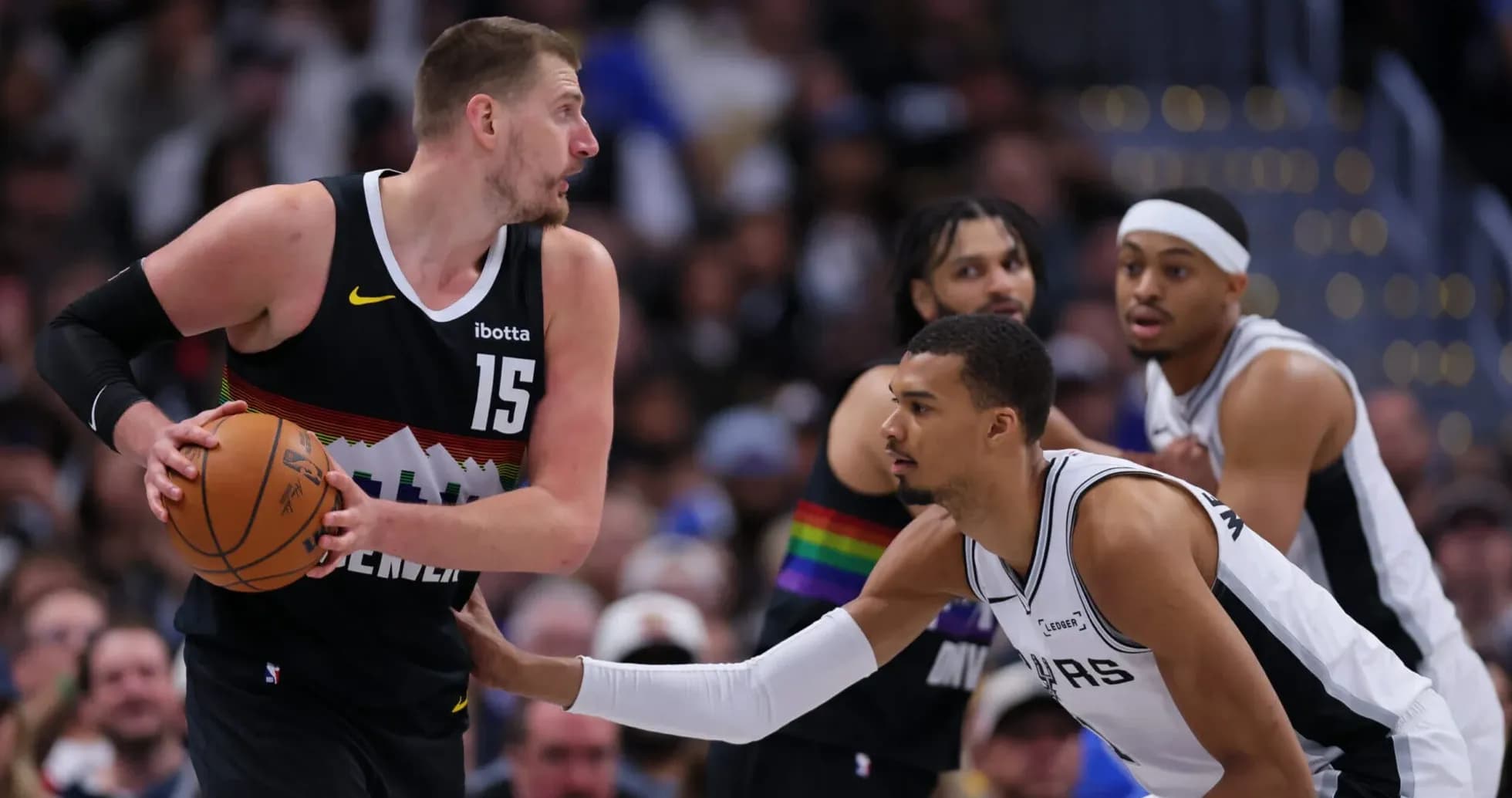 Nikola Jokić dribbling past defender during game Nikola Jokić dribbling past defender during game