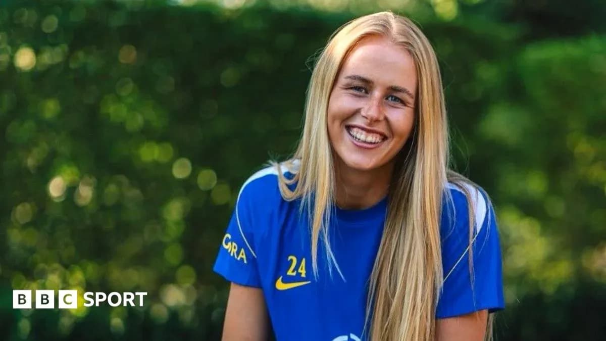 Futbolchi kulrang ko'ylakda tabassum qilmoqda Futbolchi kulrang ko'ylakda tabassum qilmoqda