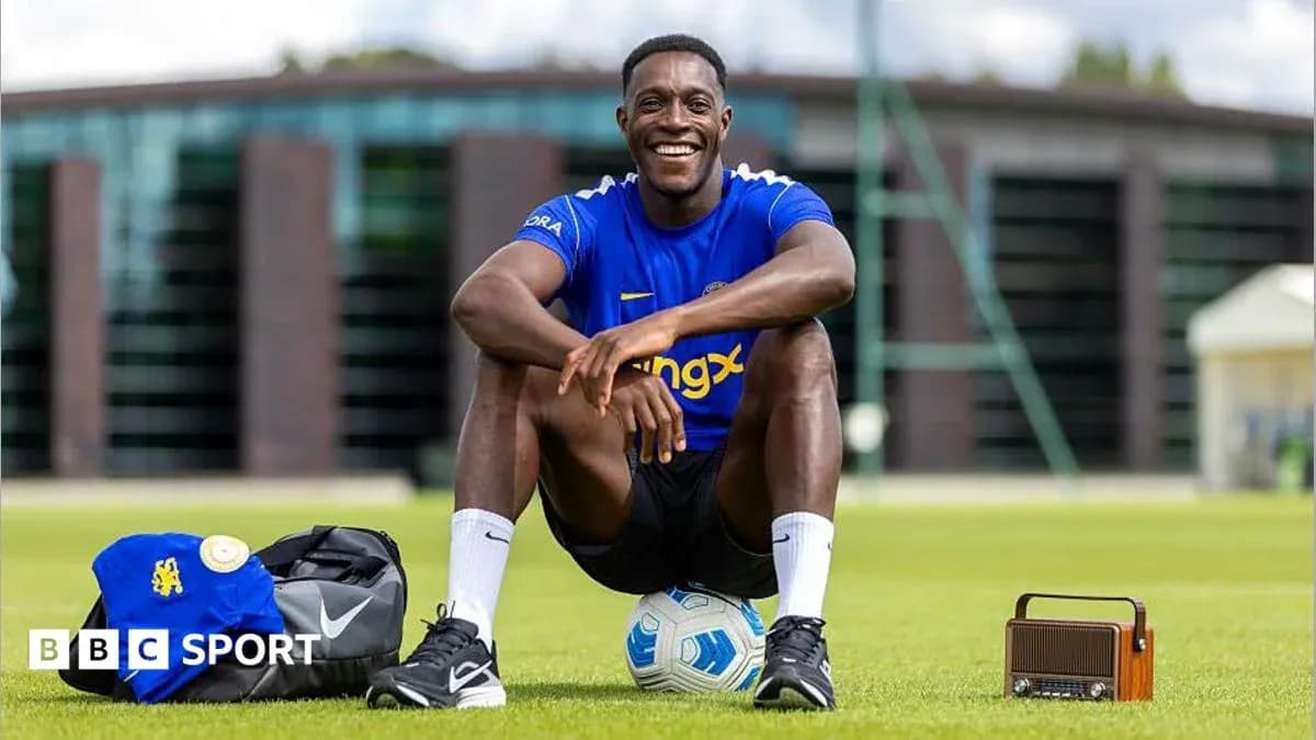 Futbolchi maydonda kulayotgan holda o'tirgan Futbolchi maydonda kulayotgan holda o'tirgan