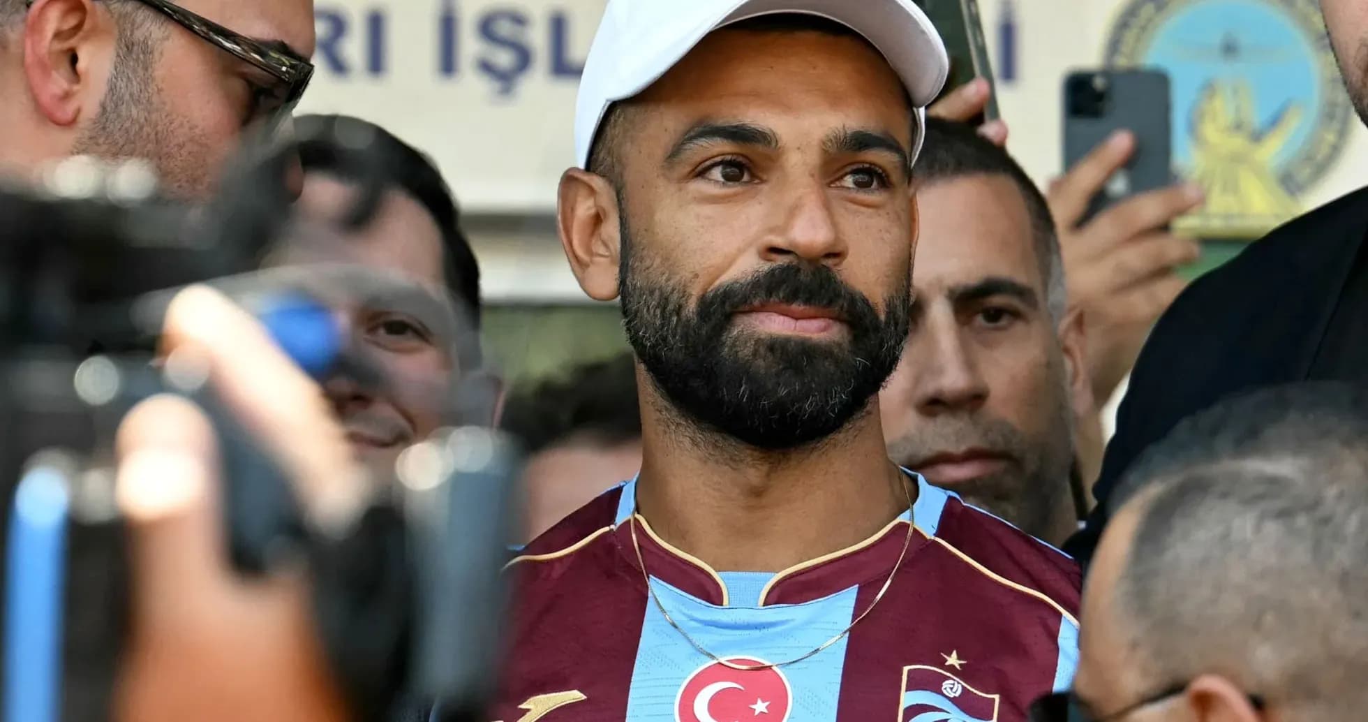 Futbolchi, jurnalistlar orasida turib, kameralar qarshisida Futbolchi, jurnalistlar orasida turib, kameralar qarshisida