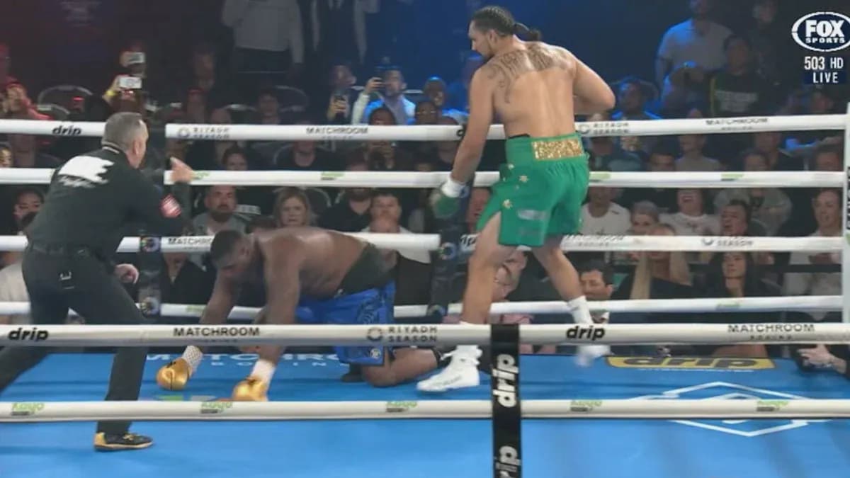 Boxer in green celebrates as opponent kneels Boxer in green celebrates as opponent kneels