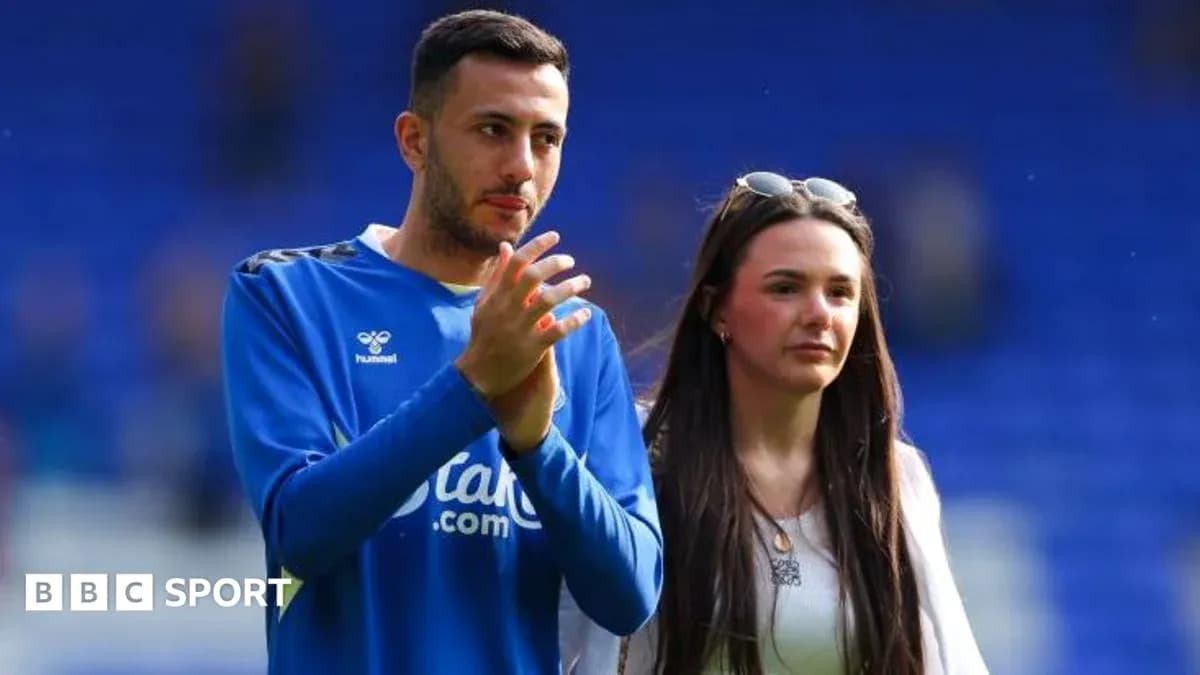 Football player and companion walking on the pitch Football player and companion walking on the pitch